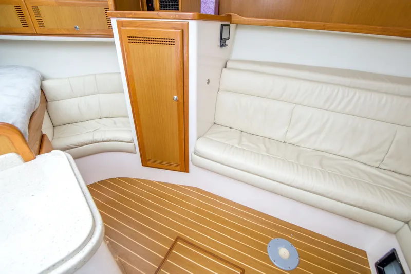 Slide: The Image of Interior of 2005 Cabo 35 Express yacht with cream leather seating and wooden flooring. - 24