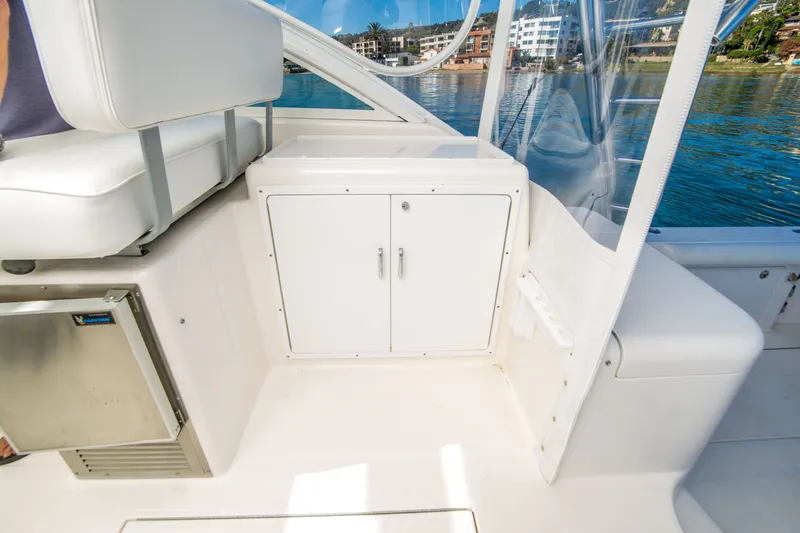 Slide: The Image of 2005 Cabo 35 Express boat interior with seating and storage, docked by the water. - 17