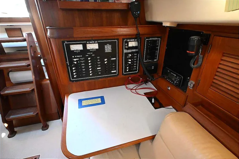 Slide: The Image of Navigation station of 2002 Island Packet 350 sailboat with control panels and communication equipment. - 35