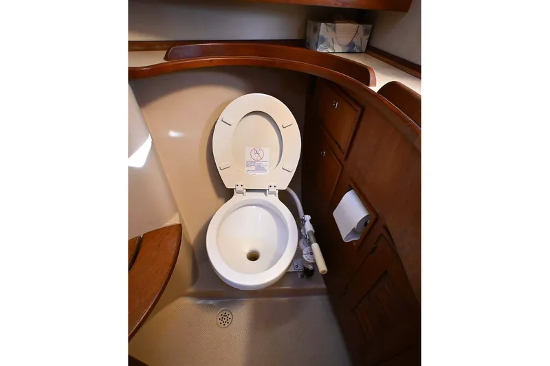 Slide: The Image of 2002 Island Packet 350 yacht bathroom with toilet and wooden cabinetry. - 47