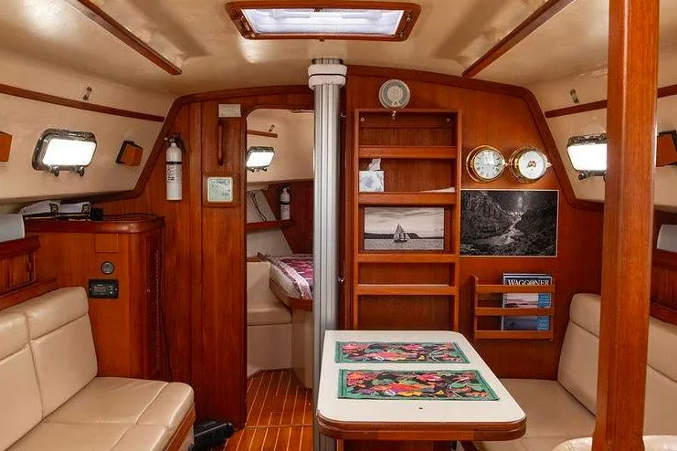 Slide: The Image of Interior of 2002 Island Packet 350 sailboat with cozy seating and wooden finishes. - 30