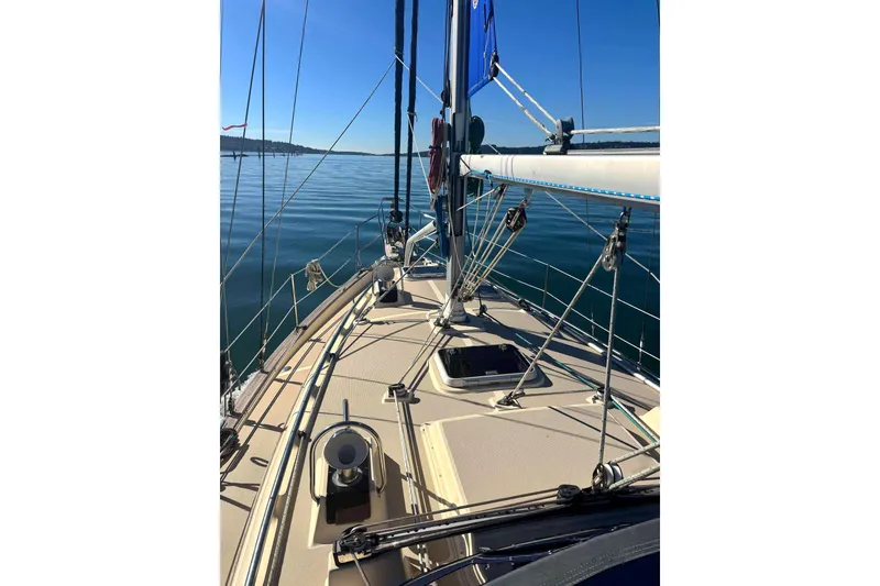 Slide: The Image of 2002 Island Packet 350 sailboat deck with clear blue sky and calm waters. - 5