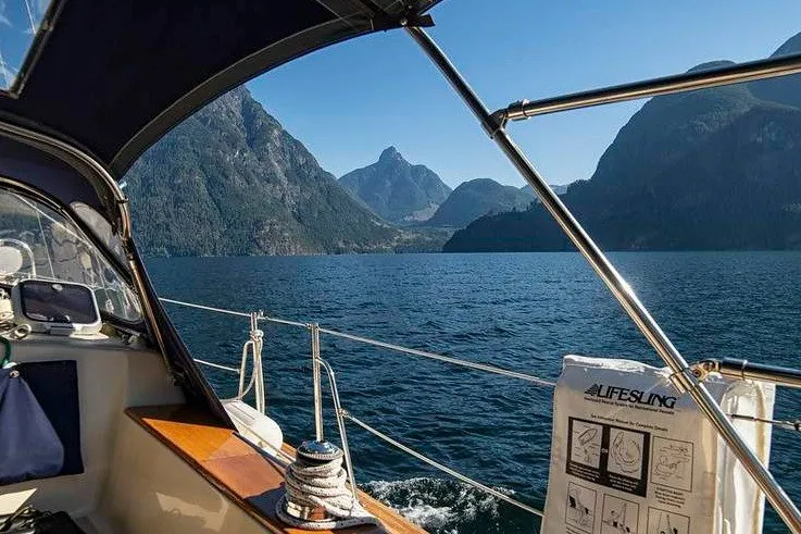 Slide: The Image of Sailing on a 2002 Island Packet 350 with scenic mountain and lake views. - 26