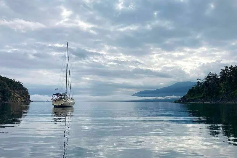 Slide: The Image of Sailboat Island Packet 350 (2002) anchored in serene, misty coastal waters. - 1