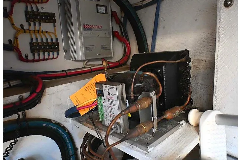 Slide: The Image of Electrical components inside a 2002 Island Packet 350 sailboat, featuring wiring and control systems. - 92