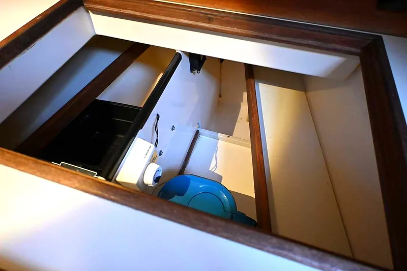 Slide: The Image of Storage compartment inside 2002 Island Packet 350 sailboat, featuring wooden trim and equipment. - 59