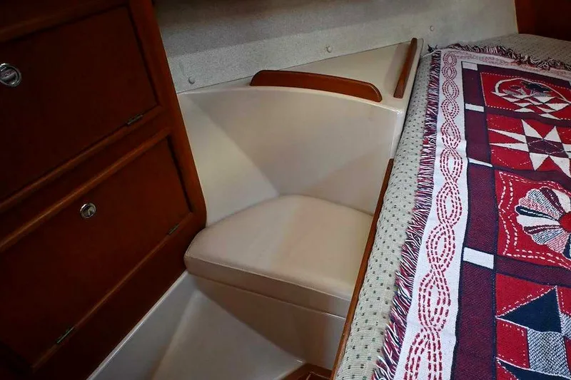 Slide: The Image of Interior of a 2002 Island Packet 350 sailboat with wooden cabinetry and patterned bedding. - 41