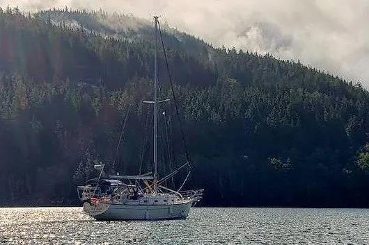 Slide: The Image of Sailboat Island Packet 350 (2002) on serene water with forested hills in the background. - 2