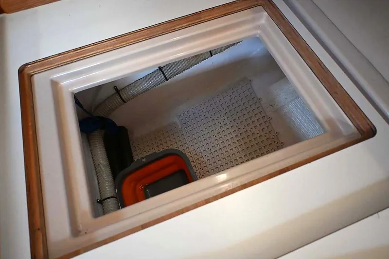 Slide: The Image of Storage compartment on a 2002 Island Packet 350 sailboat, featuring hoses and equipment. - 73