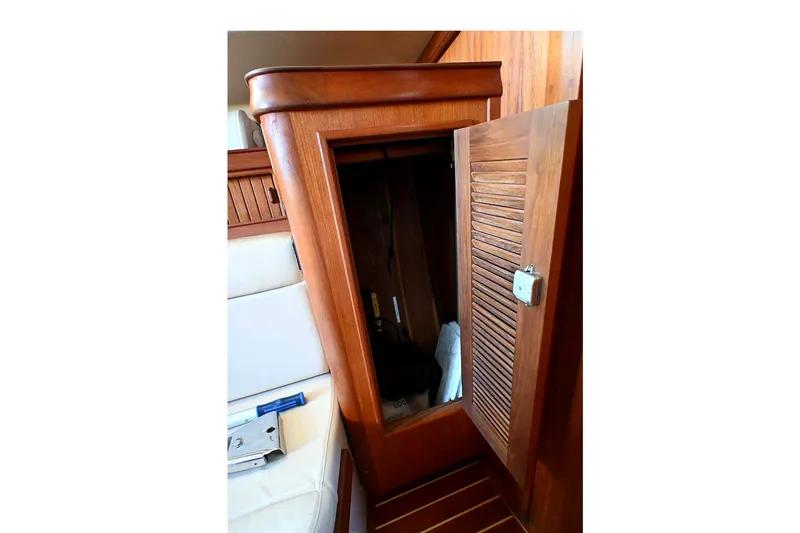 Slide: The Image of Interior wooden cabinet on 2002 Island Packet 350 sailboat, open door revealing storage space. - 43