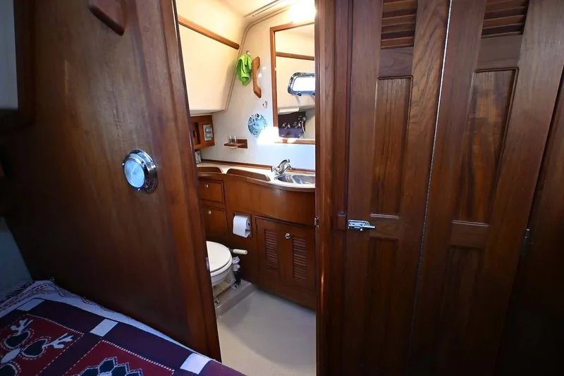 Slide: The Image of Interior of 2002 Island Packet 350 sailboat showing wooden bathroom and cozy cabin. - 40