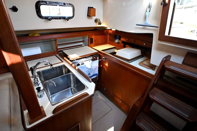 Slide: The Image of Interior of 2002 Island Packet 350 sailboat kitchen with sink and wooden cabinetry. - 53
