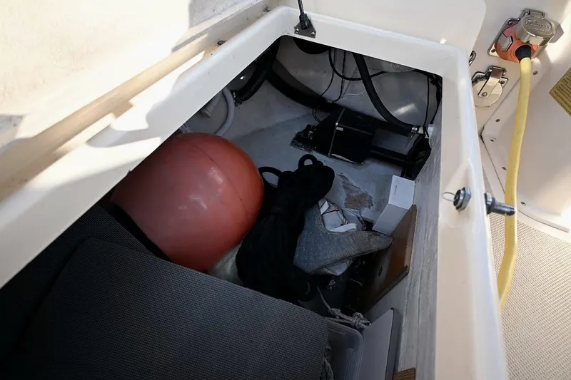 Slide: The Image of Storage compartment of 2002 Island Packet 350 sailboat with various boating equipment. - 87