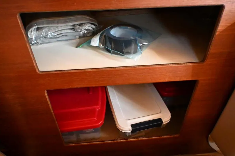 Slide: The Image of Storage compartments on a 2002 Island Packet 350 sailboat with organized supplies. - 74