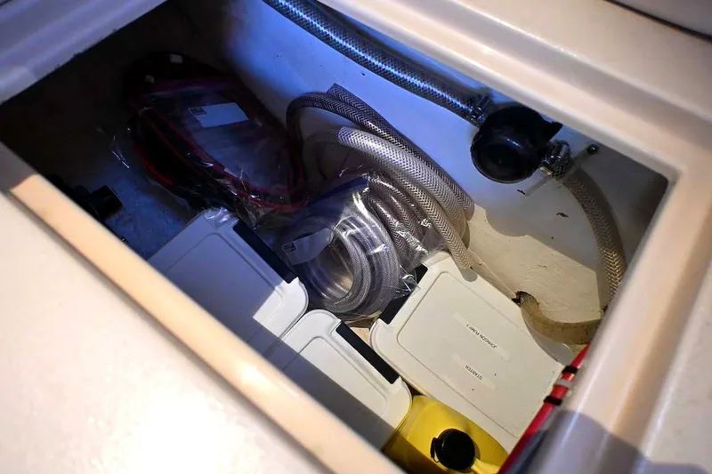 Slide: The Image of Storage compartment on a 2002 Island Packet 350 sailboat with hoses and containers. - 66