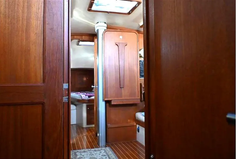 Slide: The Image of Interior view of 2002 Island Packet 350 sailboat with wooden cabinetry and flooring. - 62