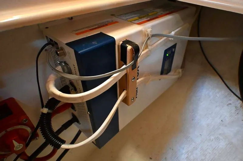 Slide: The Image of Electrical setup inside a 2002 Island Packet 350 sailboat, featuring cables and components. - 68
