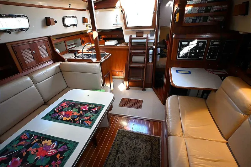 Slide: The Image of Interior of 2002 Island Packet 350 sailboat with cozy seating and wooden finishes. - 32