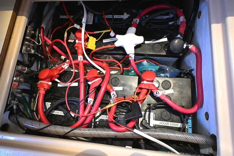 Slide: The Image of Battery compartment of a 2002 Island Packet 350 sailboat with labeled wiring. - 65
