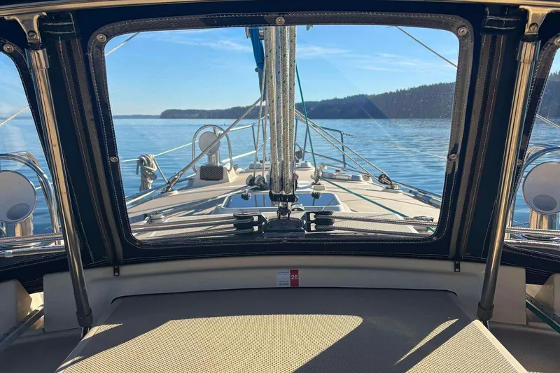 Slide: The Image of View from 2002 Island Packet 350 sailboat cockpit, overlooking calm waters and distant shoreline. - 11