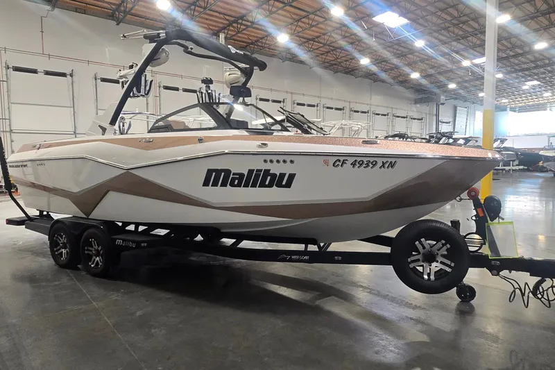 The Image of 2022 Malibu Wakesetter 25 LSV boat on trailer in warehouse setting. - 0