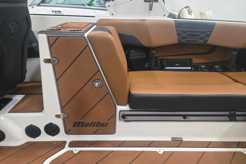 Slide: The Image of 2022 Malibu Wakesetter 25 LSV interior with tan and black seating, cup holders, and sleek design. - 14