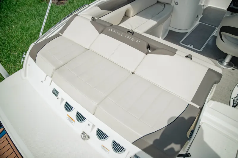 Slide: The Image of 2019 Bayliner 215 Deck Boat interior with cushioned seating and sleek design. - 8