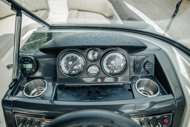 Slide: The Image of Dashboard of a 2019 Bayliner 215 Deck Boat with gauges and cup holders. - 14