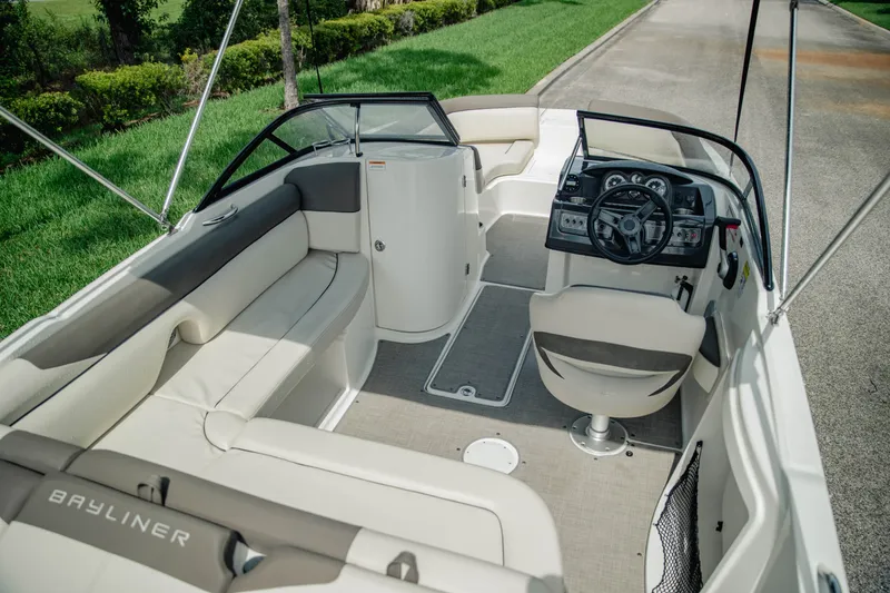 Slide: The Image of 2019 Bayliner 215 Deck Boat interior with seating and steering console. - 11