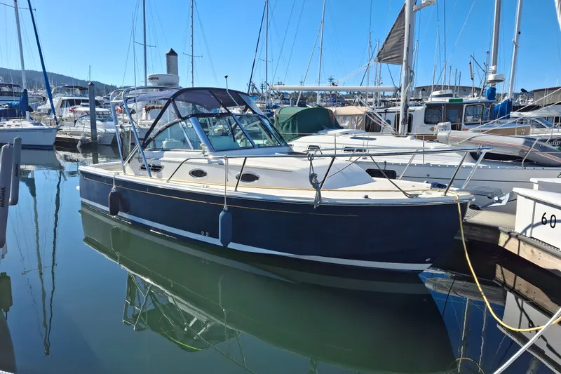 Slide: The Image of 2005 Back Cove 26 boat docked in a marina, surrounded by sailboats. - 3