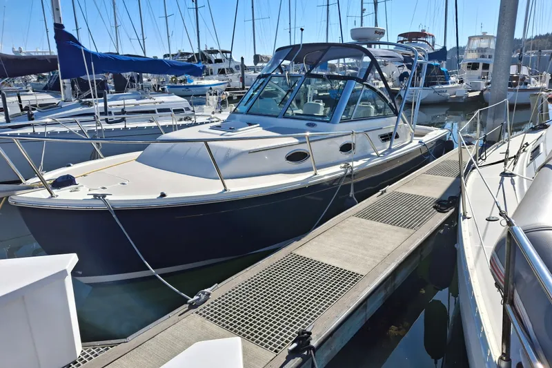 Slide: The Image of 2005 Back Cove 26 boat docked at a marina, surrounded by other vessels. - 4