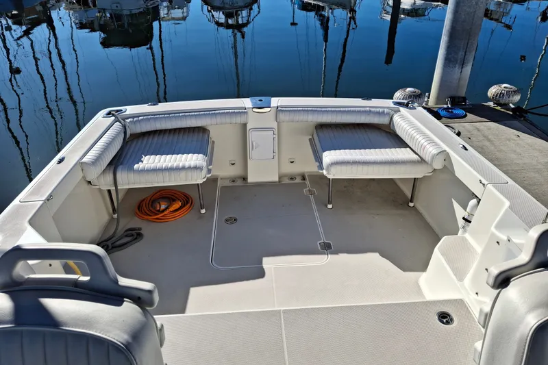 Slide: The Image of 2005 Back Cove 26 boat interior with cushioned seating and docked marina view. - 8