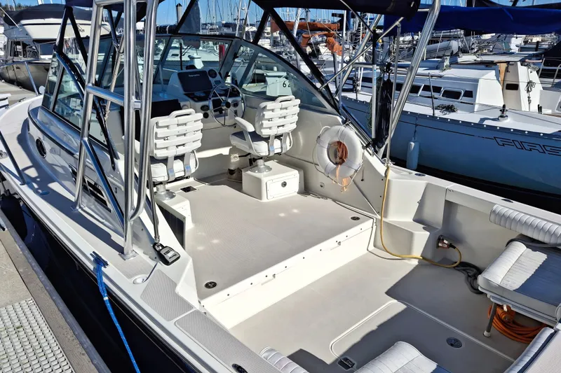 Slide: The Image of 2005 Back Cove 26 boat interior with seating and steering wheel at marina. - 7