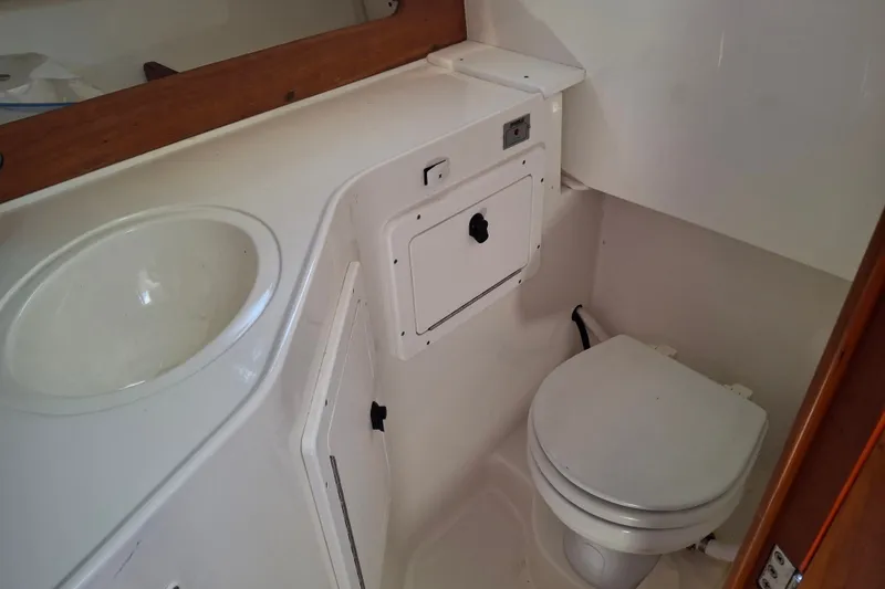 Slide: The Image of 2005 Back Cove 26 boat bathroom with sink and toilet, compact and functional design. - 17