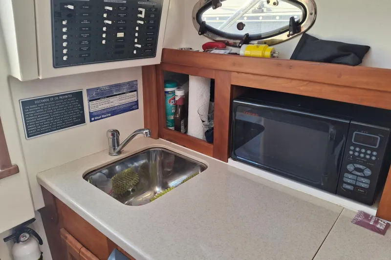 Slide: The Image of Compact galley in 2005 Back Cove 26 boat with sink, microwave, and storage. - 15