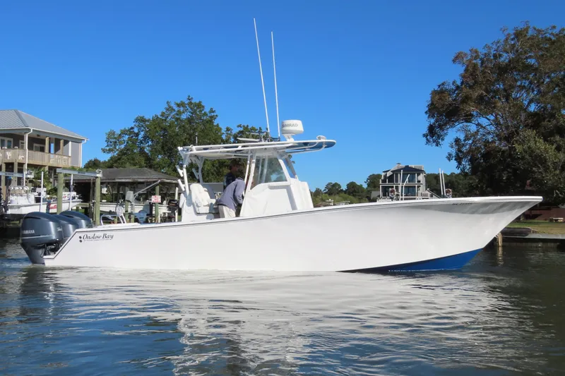 Slide: The Image of 2018 Onslow Bay 33 Tournament Edition boat on calm water near docks. - 8