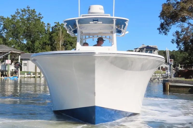 Slide: The Image of 2018 Onslow Bay 33 Tournament Edition boat on water, front view, with trees and docks in background. - 4