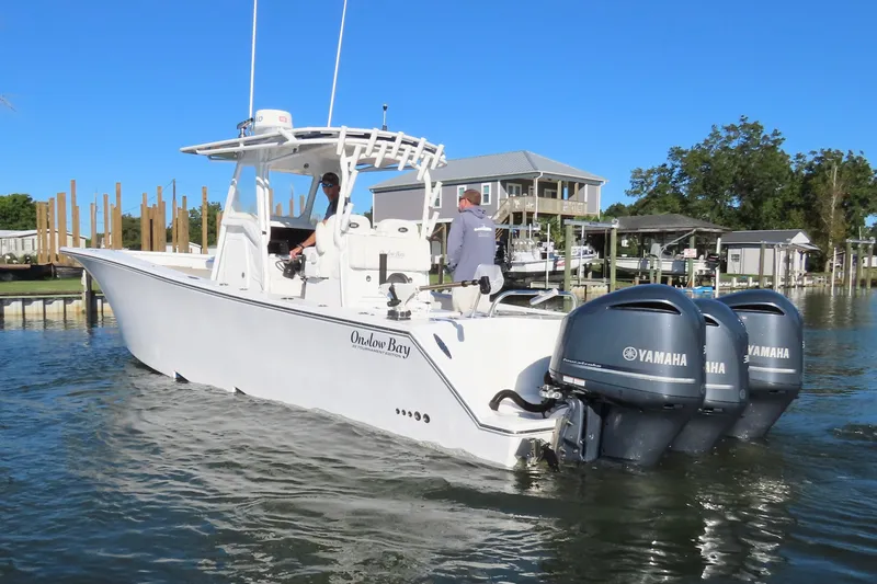 Slide: The Image of 2018 Onslow Bay 33 Tournament Edition boat with triple Yamaha engines on calm water. - 12