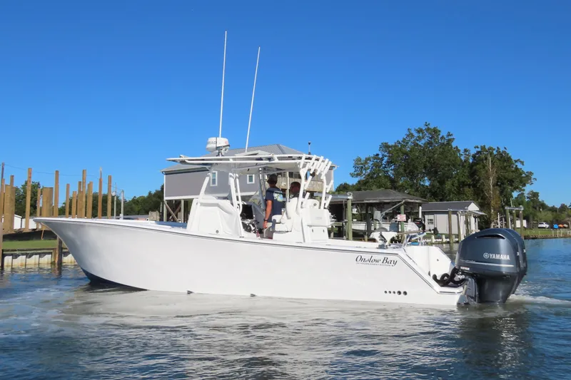Slide: The Image of 2018 Onslow Bay 33 Tournament Edition boat on water, clear sky background. - 13