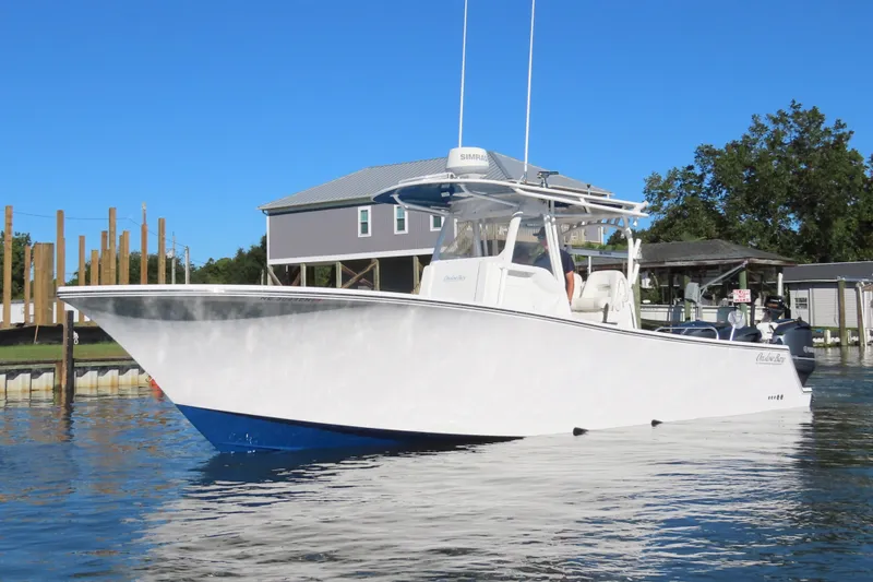 Slide: The Image of 2018 Onslow Bay 33 Tournament Edition boat docked on calm water. - 9