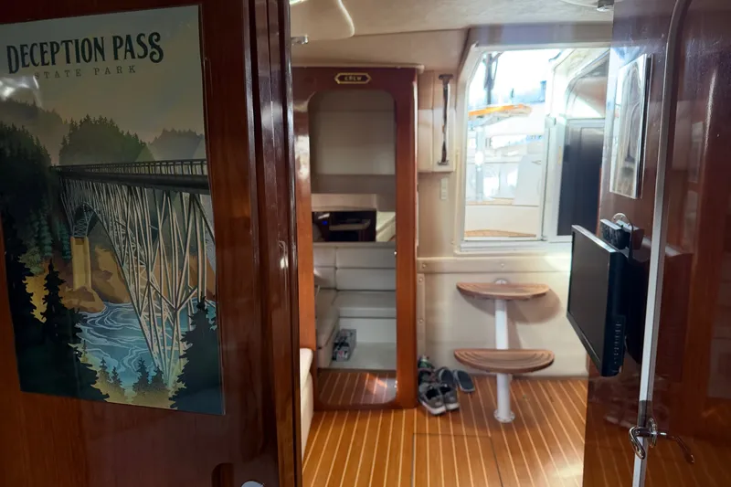 Slide: The Image of Interior of 2005 Regal Commodore 3560 yacht with wood flooring and Deception Pass poster. - 29