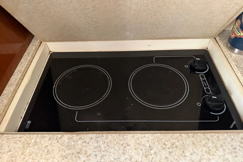 Slide: The Image of Built-in stovetop on 2005 Regal Commodore 3560 yacht, featuring two burners and control knobs. - 23