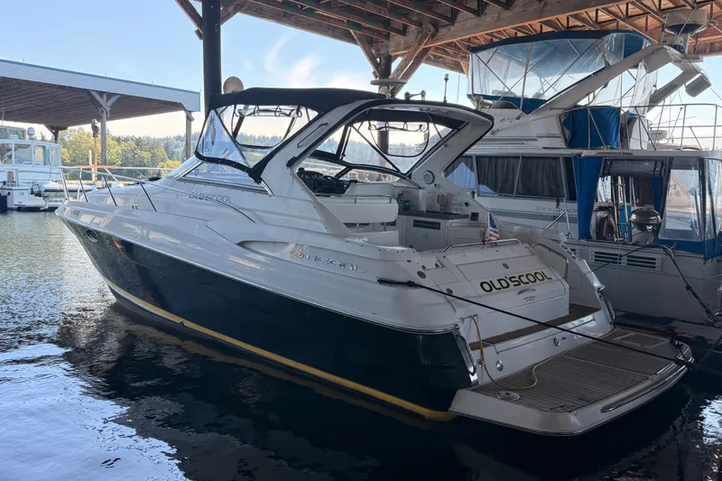 Slide: The Image of 2005 Regal Commodore 3560 yacht docked in a marina under a wooden canopy. - 1