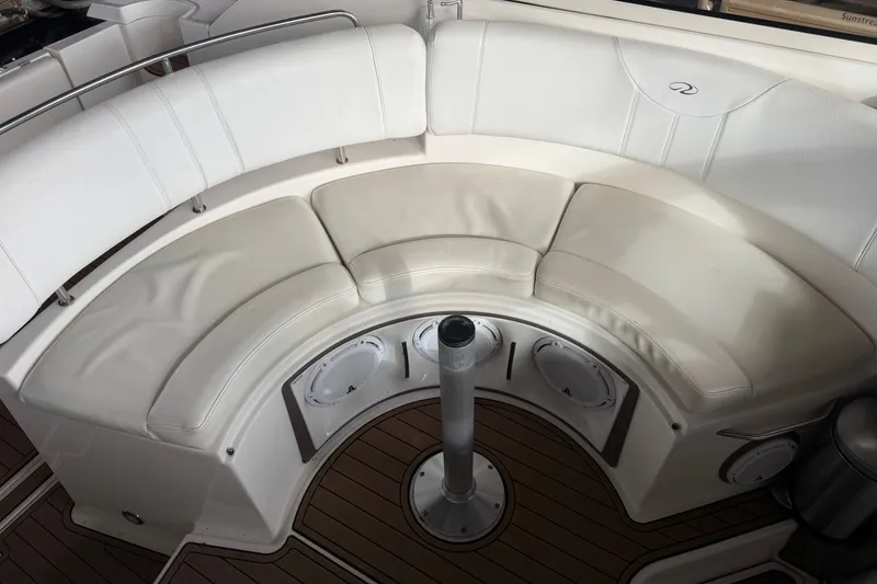 Slide: The Image of 2005 Regal Commodore 3560 boat interior with curved white seating and wood flooring. - 11