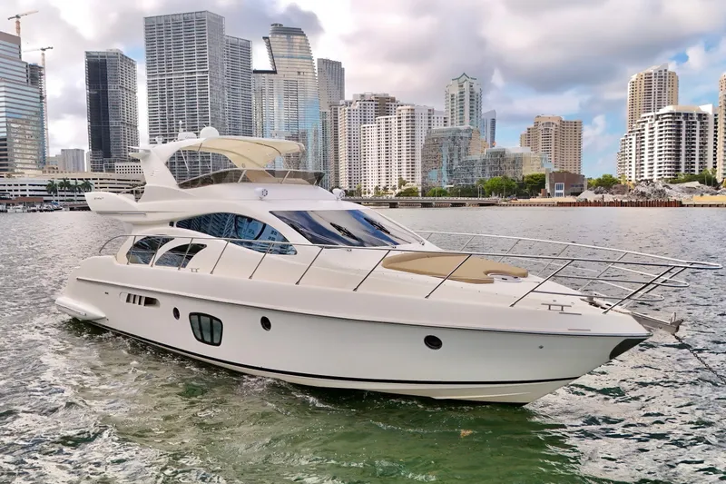 Slide: The Image of Luxury 2007 Azimut 55E yacht cruising near city skyline, showcasing sleek design and elegance. - 1