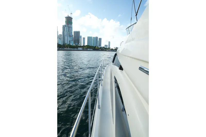 Slide: The Image of Side view of a 2007 Azimut 55E yacht cruising near a city skyline. - 23