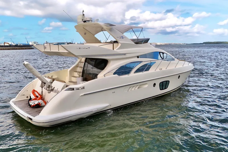The Image of 2007 Azimut 55E yacht cruising on open water under a partly cloudy sky. - 0
