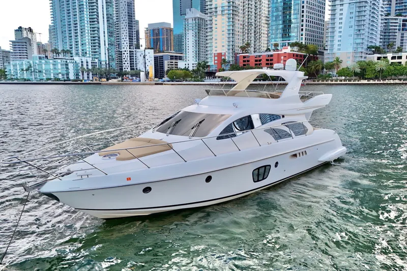 Slide: The Image of Luxury 2007 Azimut 55E yacht cruising near urban skyline, showcasing sleek design and elegance. - 4