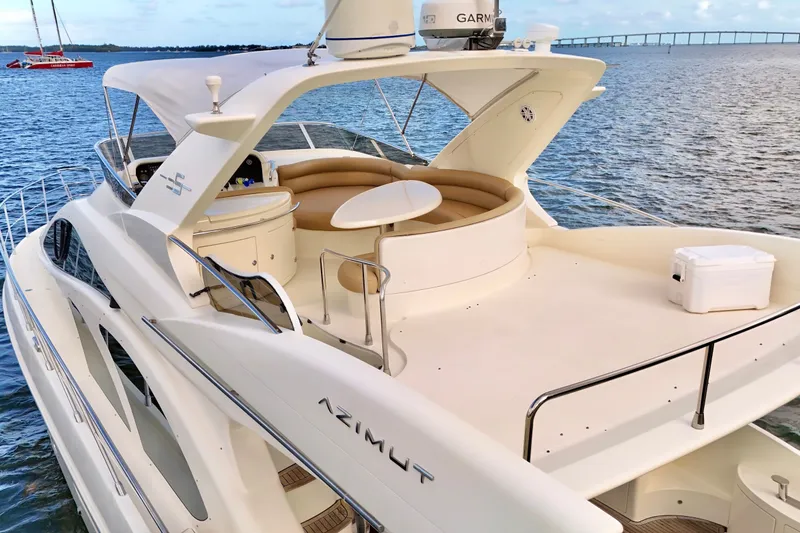 Slide: The Image of 2007 Azimut 55E yacht with spacious deck and seating, cruising on calm waters. - 16