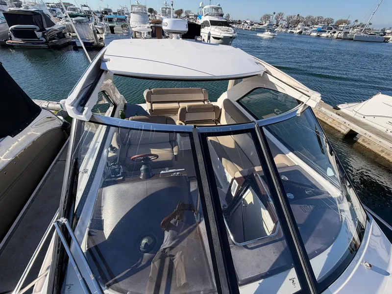 Slide: The Image of A 2013 Regal 35 Sport Coupe docked in a marina. It features an open cockpit and comfortable seating. - 17